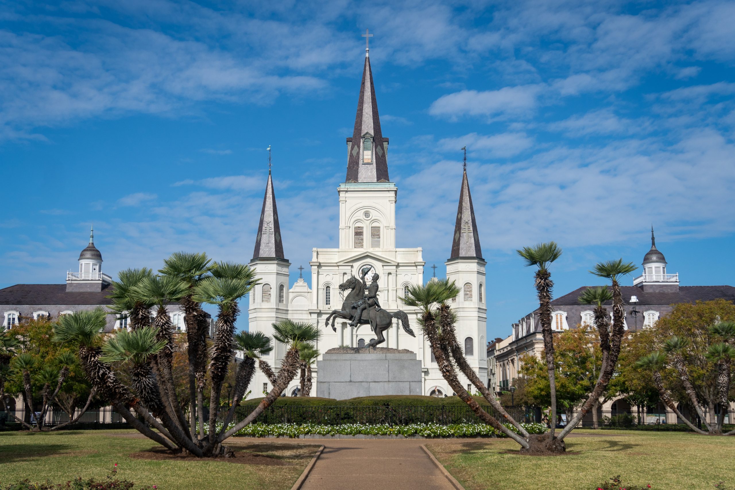 A scenic view of Jackson Square in New Orleans' French Quarter, featuring the iconic equestrian statue of Andrew Jackson and the historic St. Louis Cathedral