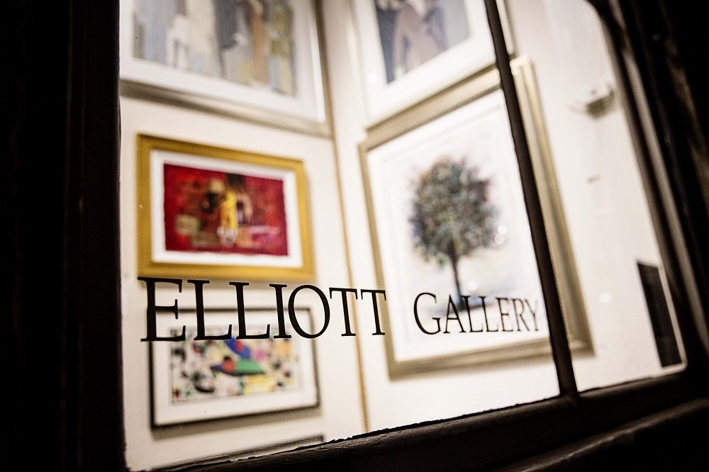 View through the Elliott Gallery window showcasing artwork for an art collection in New Orleans