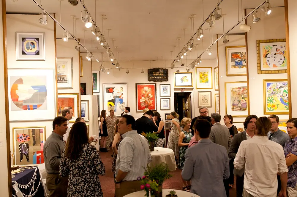 new-orleans-art-gallery Hosting an opening reception: guests mingle among framed art at Elliott Gallery, a New Orleans art gallery